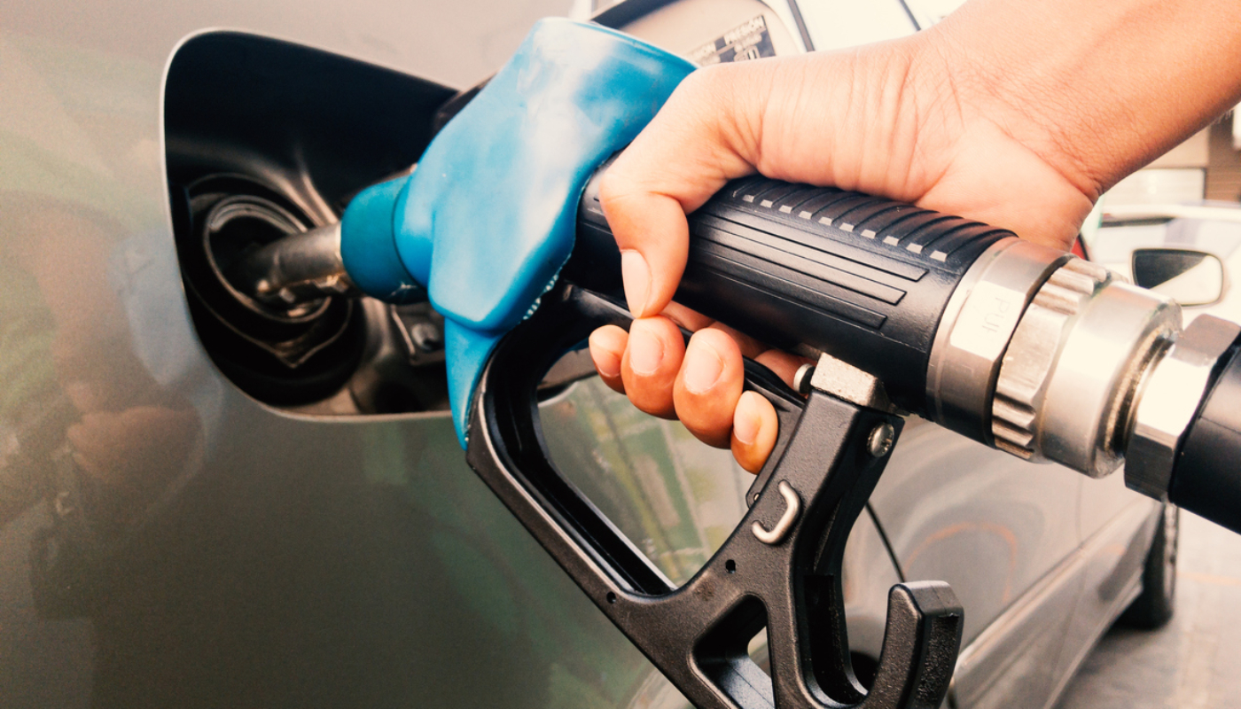 Hand holding gasoline nozzle for car refueling at gas station